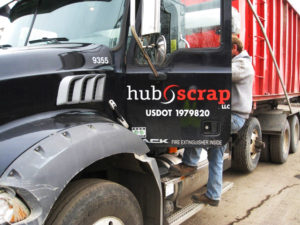 worker getting inside hub scrap truck